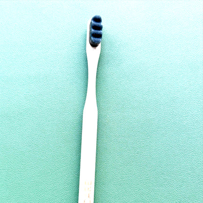 Gray toothbrush with blue bristles on a green background